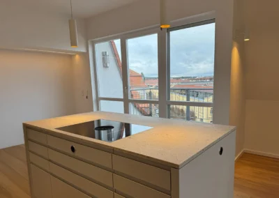 Theke in Küche mit großen Fenster und Balkon